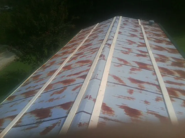 Rusted metal roof panels with new wood purlins before replacement — Storm Damage Roof Repair in Poland by Roofing Brothers