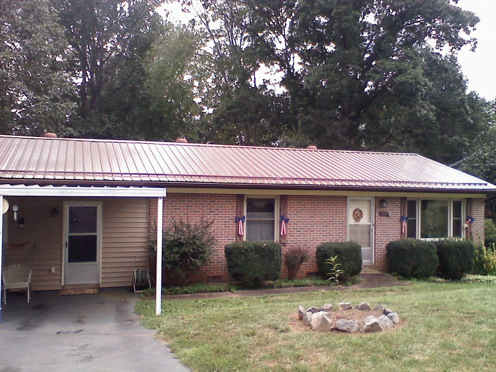 Bronze metal roof and carport on a brick ranch home — Roof Repair work by our crew in Poland